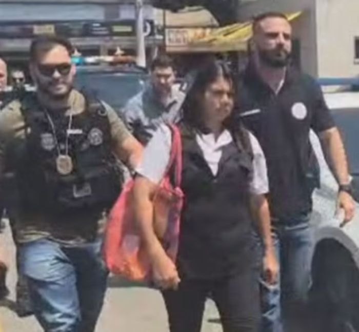 Woman in custody escorted by police officers during arrest related to alleged serial criminal and chilling confession case. Woman in custody escorted by police officers during arrest related to alleged serial criminal and chilling confession case.