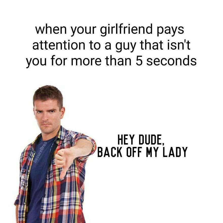 Man in plaid shirt giving thumbs down, humorously portraying alpha male jealousy over girlfriend's attention.