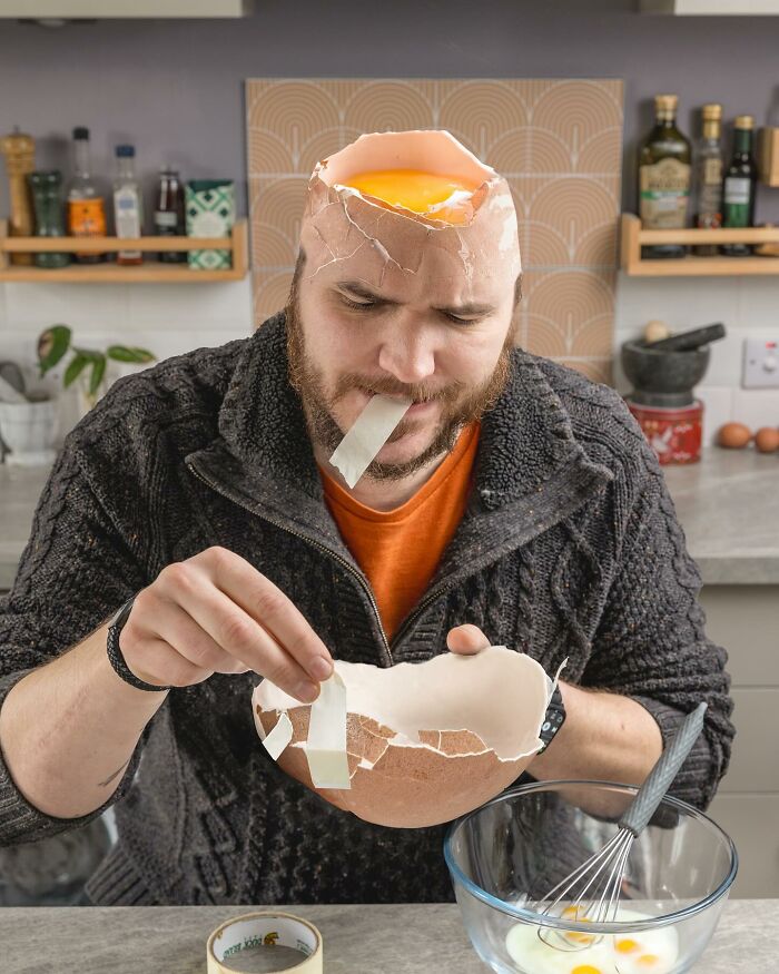 Man with c*****d egg shell head and yolk inside, holding a large broken egg shell, showcasing amazing logic-challenging photo manipulations.