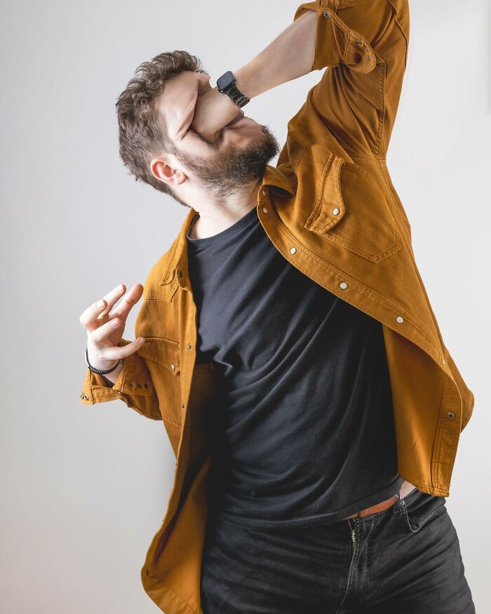 Man in orange jacket and black shirt posing with distorted arm in a logic-challenging photo manipulation artwork.