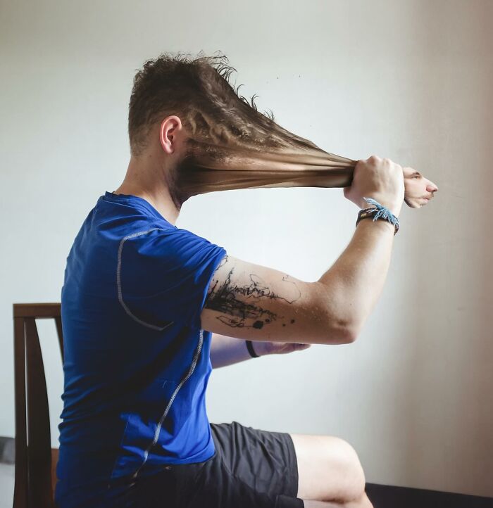 Man in blue shirt with stretched and distorted face in a creative logic-challenging photo manipulation artwork.