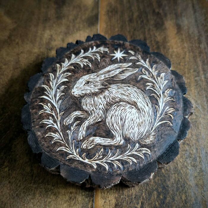 Wood-burned artwork by Canadian artist Kat Slota featuring a detailed rabbit surrounded by floral designs on wood.