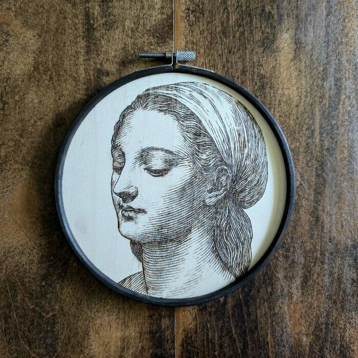 Wood-burned portrait artwork by Canadian artist Kat Slota, created using fire on light wood inside a circular frame.