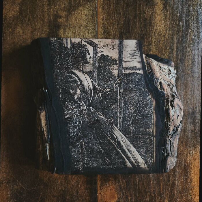 Wood-burned artwork by Canadian artist Kat Slota depicting a detailed vintage scene on a rough wood piece.