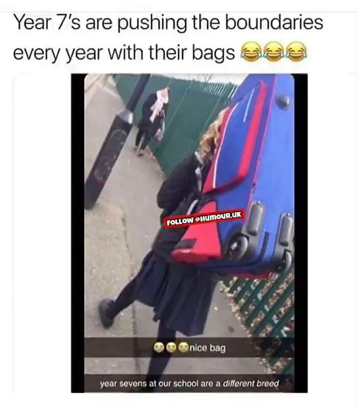 Teen carrying oversized blue and red suitcase on shoulder, showing unapologetically British humor in school setting.
