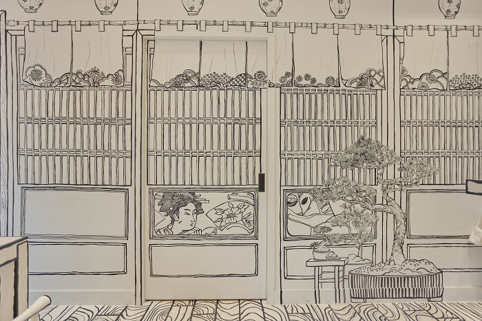 Interior of a 2D restaurant in NYC with black and white line art walls and furniture resembling a drawing. Interior of a 2D restaurant in NYC with black and white line art walls and furniture resembling a drawing.