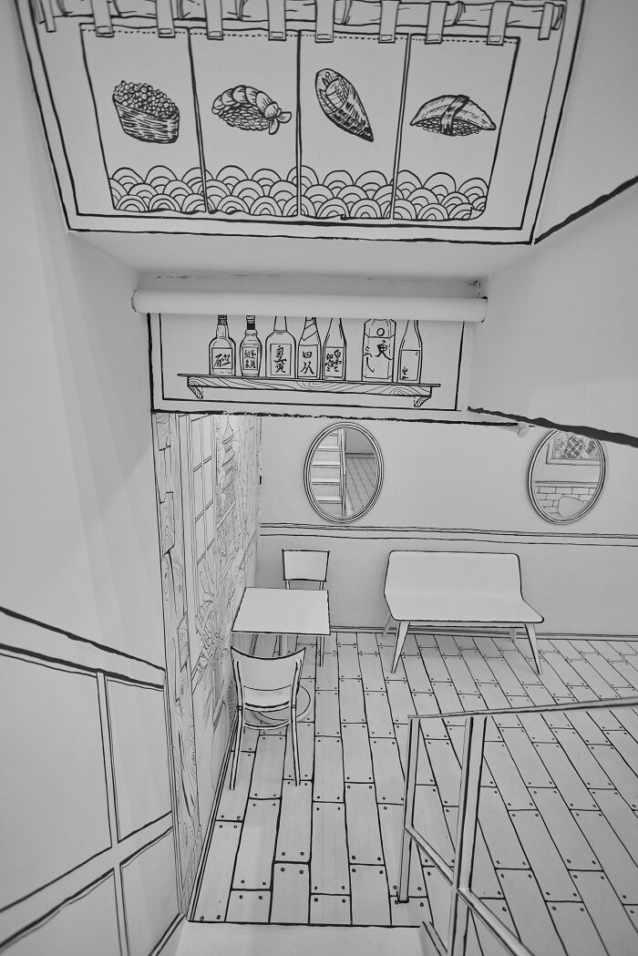 Interior of a 2D restaurant in NYC with black and white drawing-style decor and simple furniture. Interior of a 2D restaurant in NYC with black and white drawing-style decor and simple furniture.