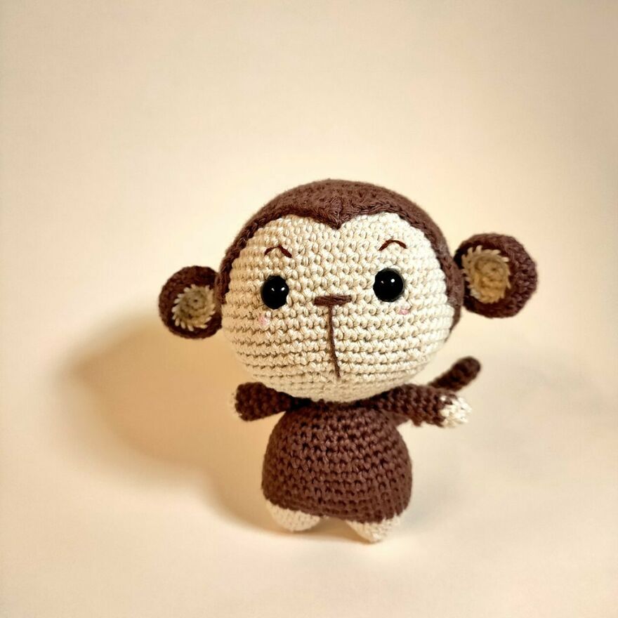 Crochet animal monkey with expressive eyes and outstretched arms, showcasing charming personality and handmade details.