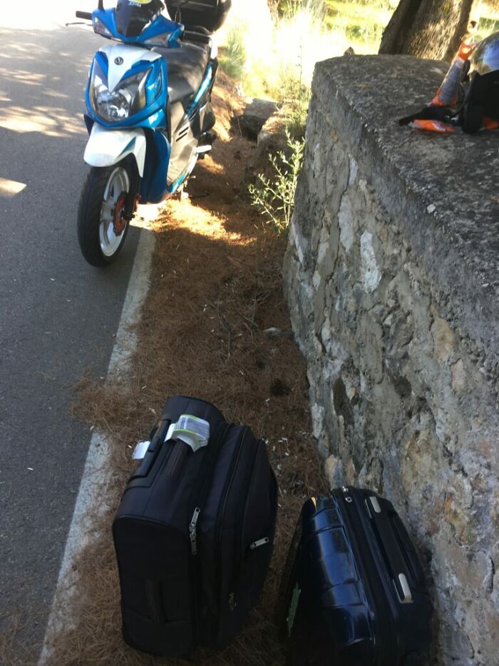 Suitcases and a blue scooter parked by a stone wall outside an Airbnb in a chaotic fairytale setting. Suitcases and a blue scooter parked by a stone wall outside an Airbnb in a chaotic fairytale setting.