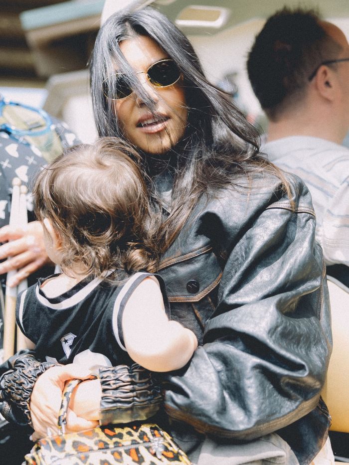 Kourtney Kardashian wearing sunglasses and black leather jacket, holding a child, related to lollipops for women’s private parts launch. Kourtney Kardashian wearing sunglasses and black leather jacket, holding a child, related to lollipops for women’s private parts launch.