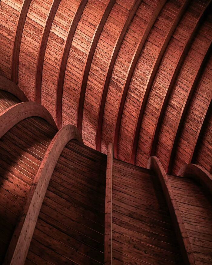 Curved wooden beams and minimalist architectural design showcasing elegant craftsmanship and smooth lines in modern construction.