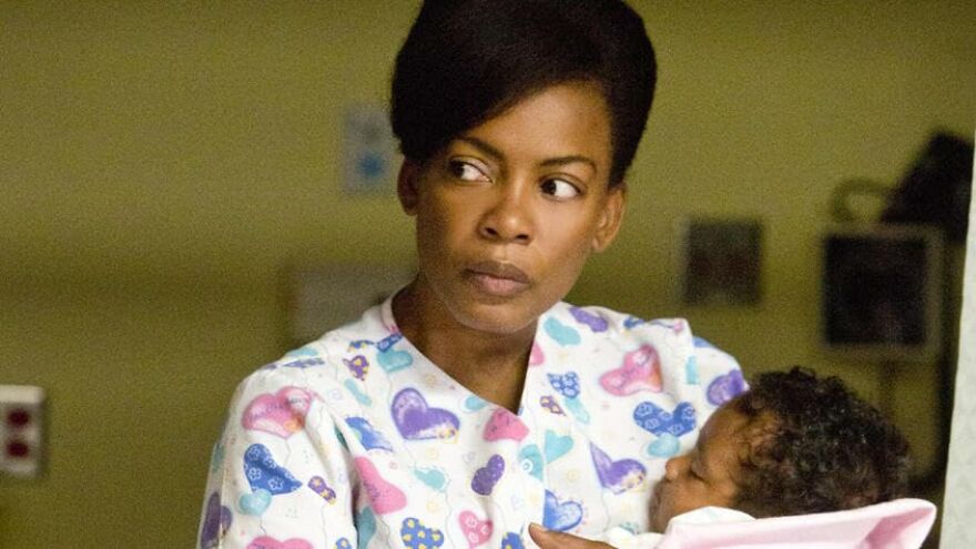 Actress holding a baby in a hospital setting, scene from a movie based on true stories that feel impossible to believe.