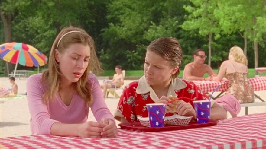 Two young people at a picnic table outdoors, a scene from movies based on true stories that feel impossible to believe.