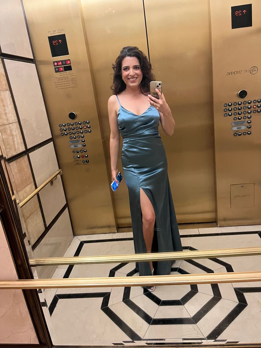Woman in a long satin dress taking a selfie in an elevator after launching billboard campaign to find love Woman in a long satin dress taking a selfie in an elevator after launching billboard campaign to find love