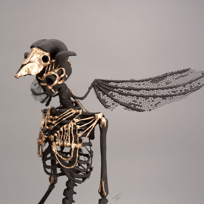 Haunting porcelain sculpture of a winged skeletal creature with gold accents, resembling relics of forgotten myths.