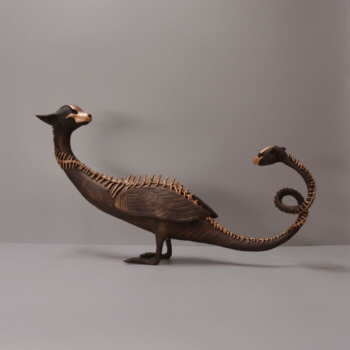 Porcelain sculpture resembling a mythical creature with intricate bone-like details and a dark, haunting finish.