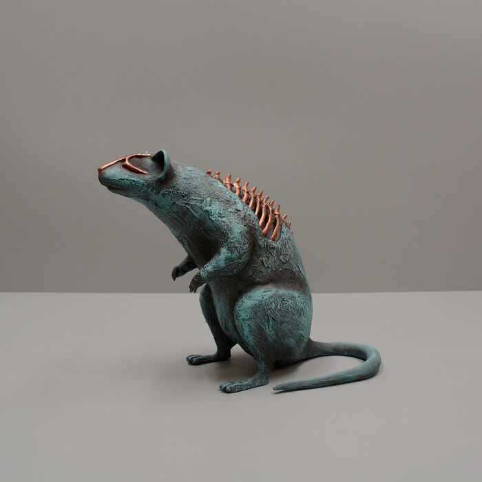 Porcelain sculpture of a mythical rat with copper accents and textured surface, resembling relics of forgotten myths.