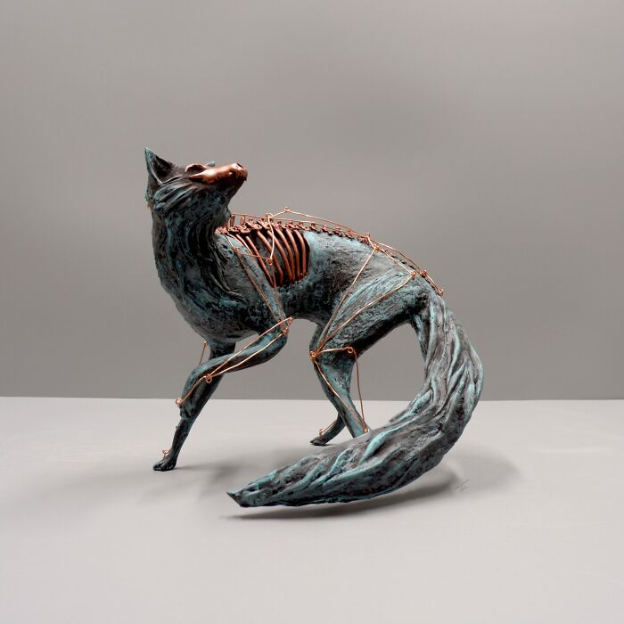 Porcelain sculpture of a fox with copper skeletal elements, evoking haunting relics of forgotten myths and ancient lore.