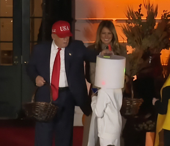 Melania Trump's White House Halloween display with Donald Trump in a red USA hat handing out candy to a child in costume Melania Trump's White House Halloween display with Donald Trump in a red USA hat handing out candy to a child in costume