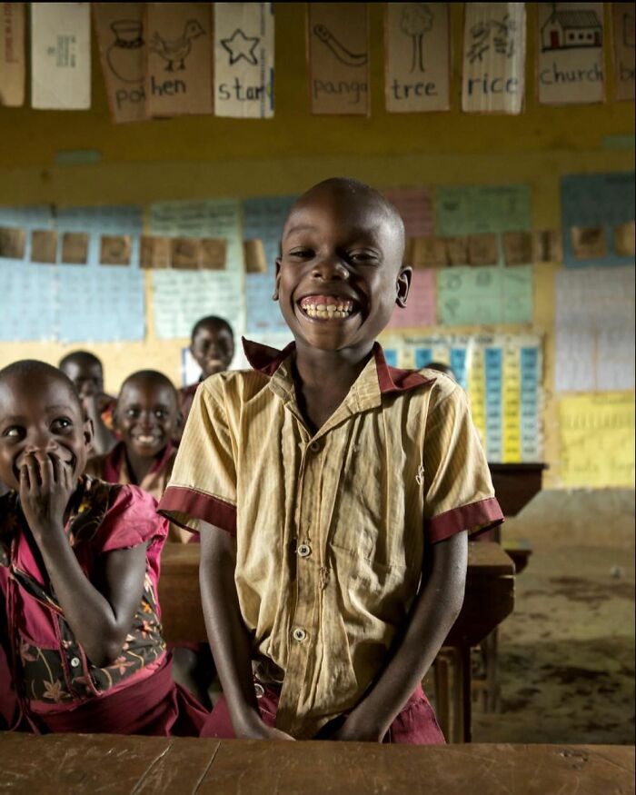 Smiling children in a classroom, showcasing joyful childhood moments around the world in a vibrant learning environment.