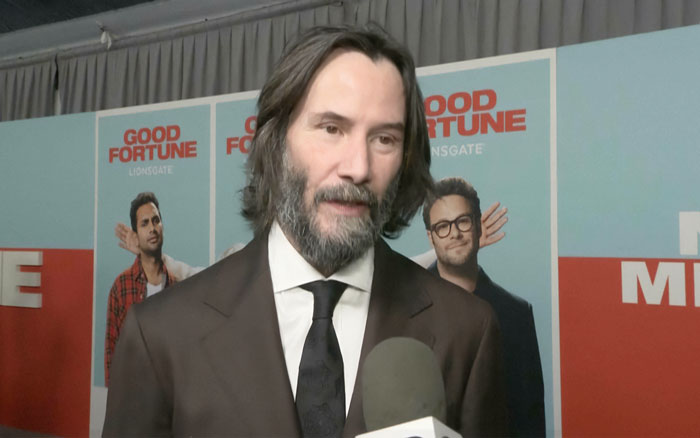 Keanu Reeves in a brown suit speaking to media, addressing Alexandra Grant marriage rumors at a movie premiere event. Keanu Reeves in a brown suit speaking to media, addressing Alexandra Grant marriage rumors at a movie premiere event.