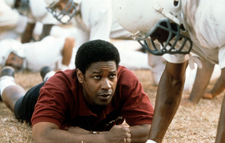 Actor coaching football players on a field scene from a movie based on true stories that feel impossible to believe.