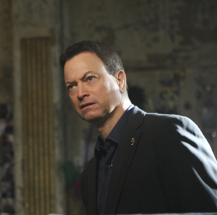 Man in a dark suit looking serious in a dimly lit room, related to unknown things about celebrities shared by people.