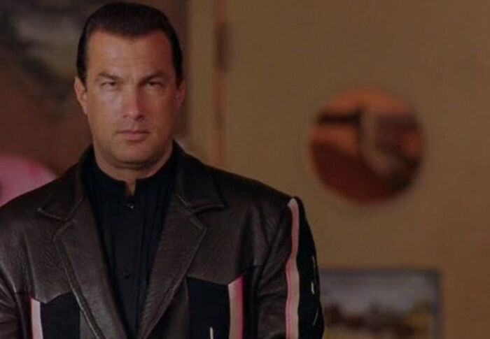 Actor Steven Seagal in a leather jacket, portraying a serious character, highlighting unknown things about celebrities.