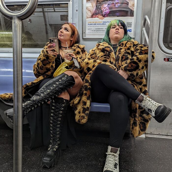 Two stylish women in leopard print coats sitting in NYC subway, captured in street portraits showcasing life underground.