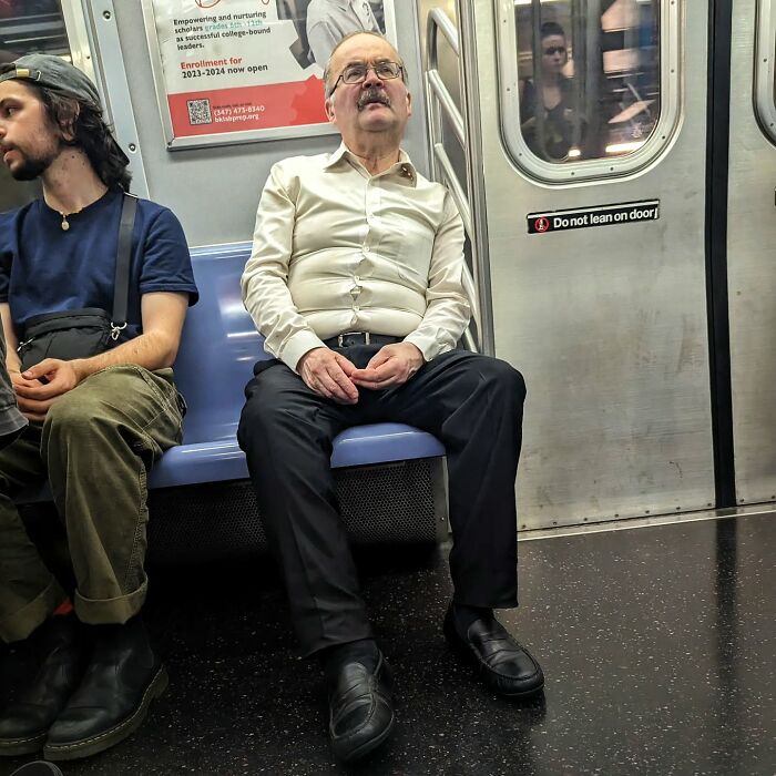 Two men sitting on a subway bench, captured in a street portrait from NYC’s subway life underground.