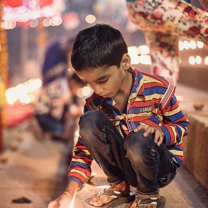 Young boy lighting a candle during a festive evening, a beautiful photo of childhood around the world shared on Instagram.