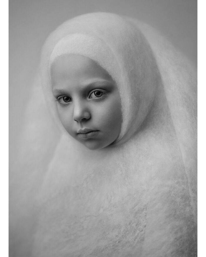 Portrait of a child wrapped in soft fabric, capturing a beautiful moment of childhood around the world in black and white.