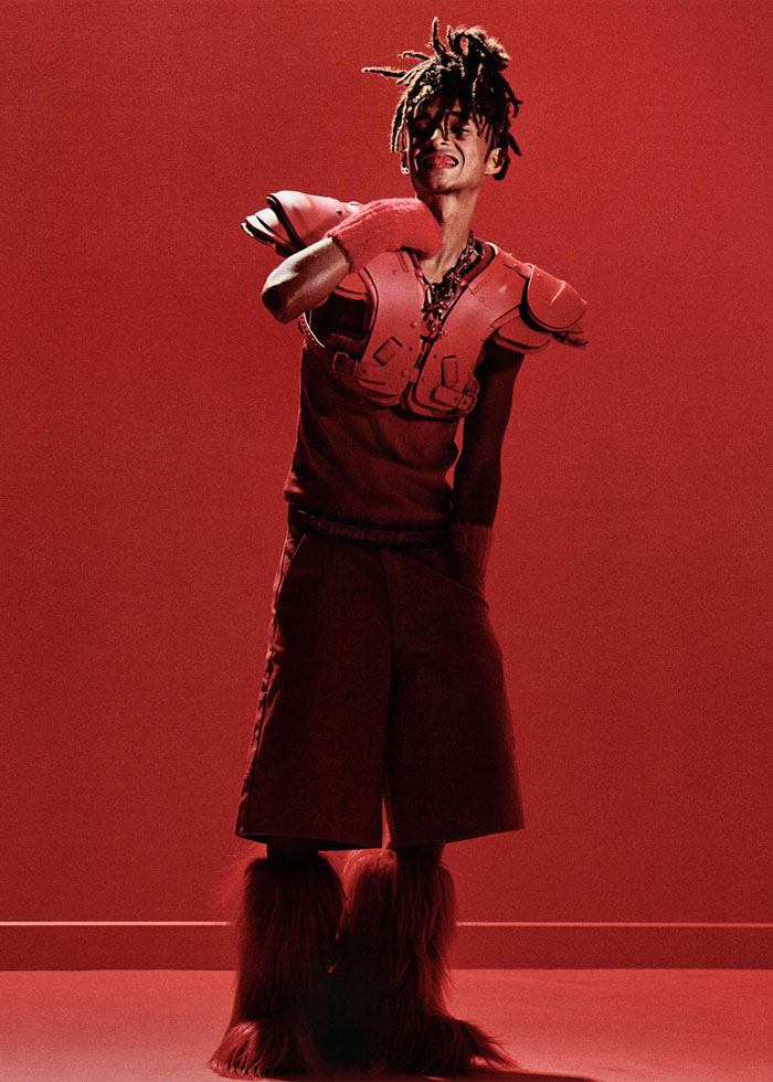 Model wearing avant-garde red outfit with oversized shoulder pads and furry boots at Paris Fashion Week 2025 celebrity looks.
