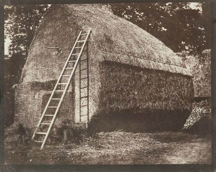Vintage photo of a haystack with a wooden ladder, showcasing early photography from the time it was a new phenomenon