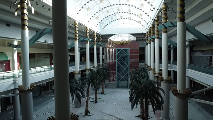 Empty ghost mall interior with palm trees and columns where urban explorers found a trapped dog needing rescue. Empty ghost mall interior with palm trees and columns where urban explorers found a trapped dog needing rescue.