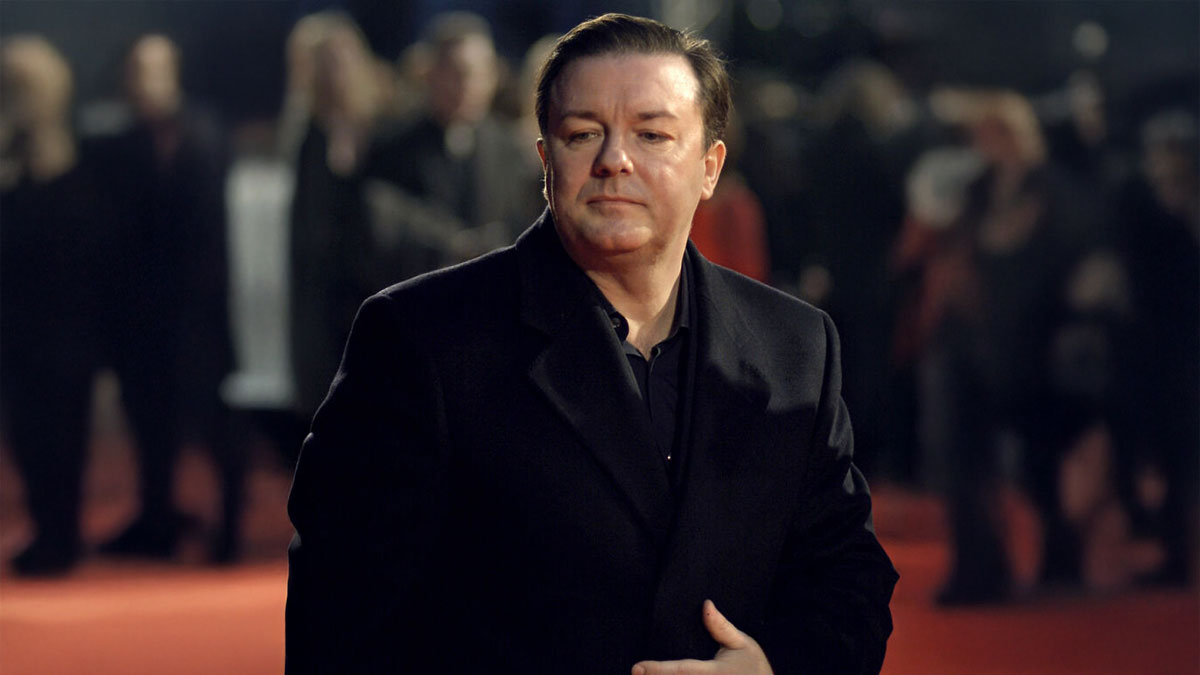 Actor attending Hollywood event, representing stars who found fame after 30, dressed in black coat on red carpet.