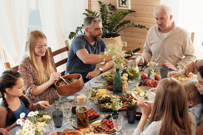 Family having a tense dinner with wife confronting brother-in-law over racist slurs while mother-in-law looks upset. Family having a tense dinner with wife confronting brother-in-law over racist slurs while mother-in-law looks upset.