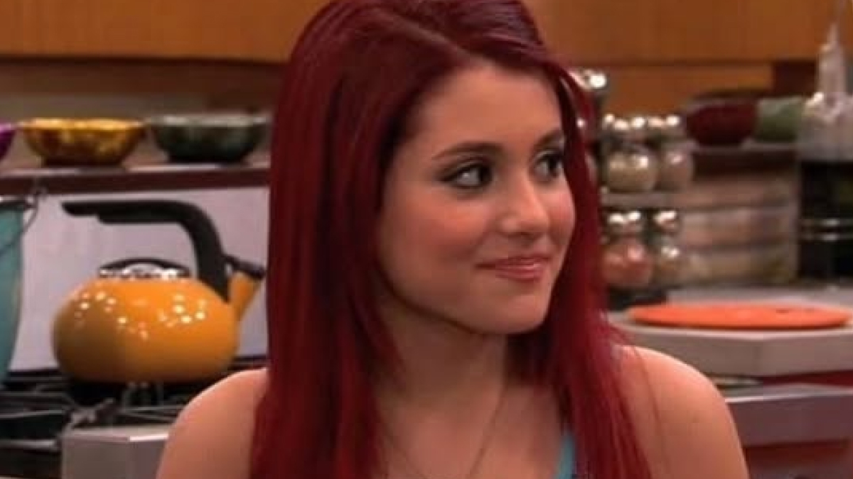 Ariana Grande with long red hair in a kitchen setting, showcasing an early phase before her rise to fame.