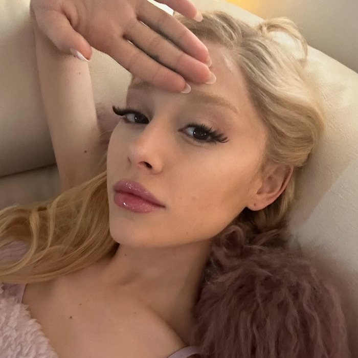 Ariana Grande with dramatic new look lying on sofa, showing glamorous makeup and long lashes, facing fan backlash. Ariana Grande with dramatic new look lying on sofa, showing glamorous makeup and long lashes, facing fan backlash.