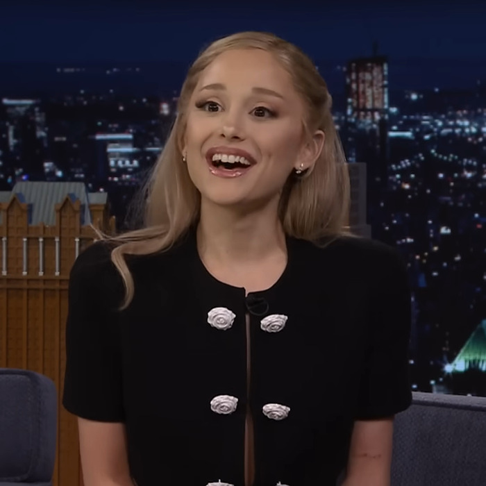 Ariana Grande with dramatic new look, blonde hair and black outfit, reacting during a nighttime TV show interview. Ariana Grande with dramatic new look, blonde hair and black outfit, reacting during a nighttime TV show interview.