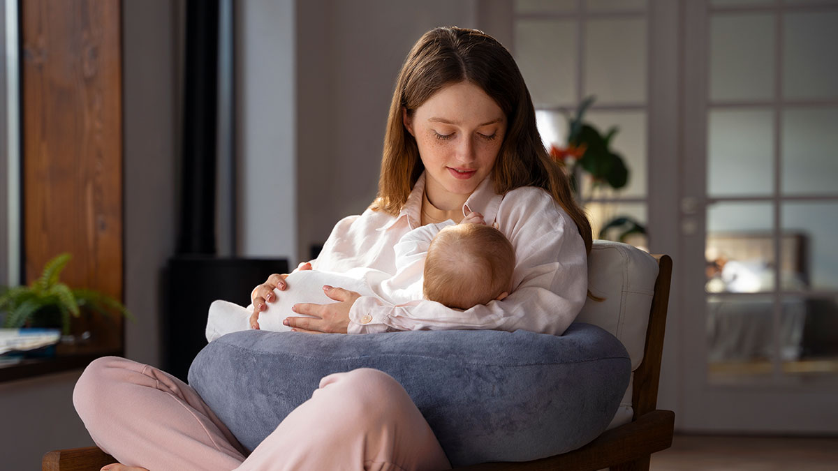 Young woman breastfeeding newborn baby in cozy room, highlighting stepsister who just gave birth with family concerns.