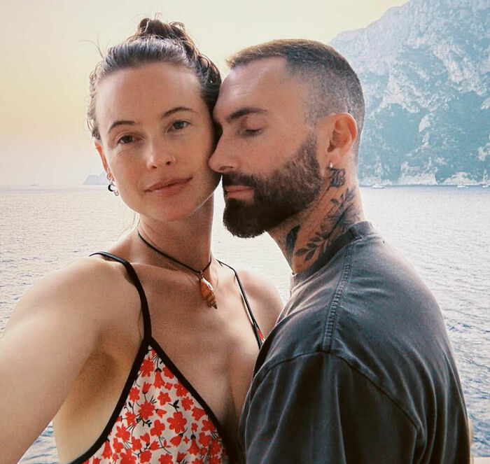 Victoria’s Secret model posing with a tattooed man by the sea with mountains in the background on a sunny day. Victoria’s Secret model posing with a tattooed man by the sea with mountains in the background on a sunny day.