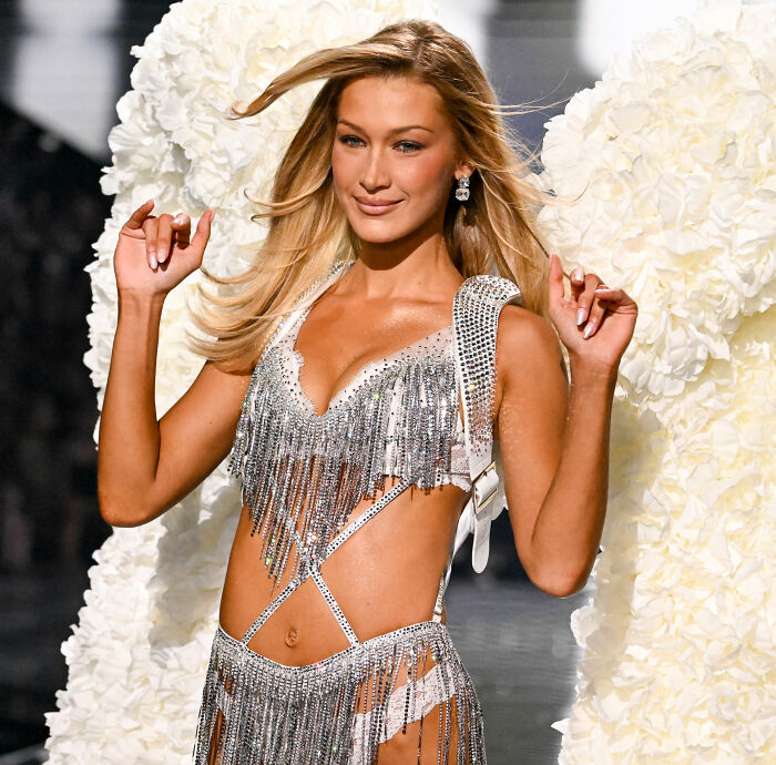 Victoria's Secret model walking runway wearing silver fringed lingerie and angel wings during fashion show. Victoria's Secret model walking runway wearing silver fringed lingerie and angel wings during fashion show.