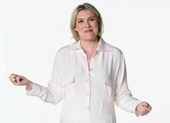 Blonde woman in a white shirt gestures while discussing Margot Robbie's provocative Wuthering Heights trailer and experts' views. Blonde woman in a white shirt gestures while discussing Margot Robbie's provocative Wuthering Heights trailer and experts' views.