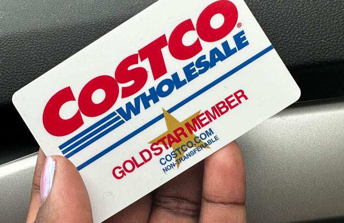 Costco Wholesale Gold Star Membership card held in hand, illustrating a loophole discovery related to membership benefits.