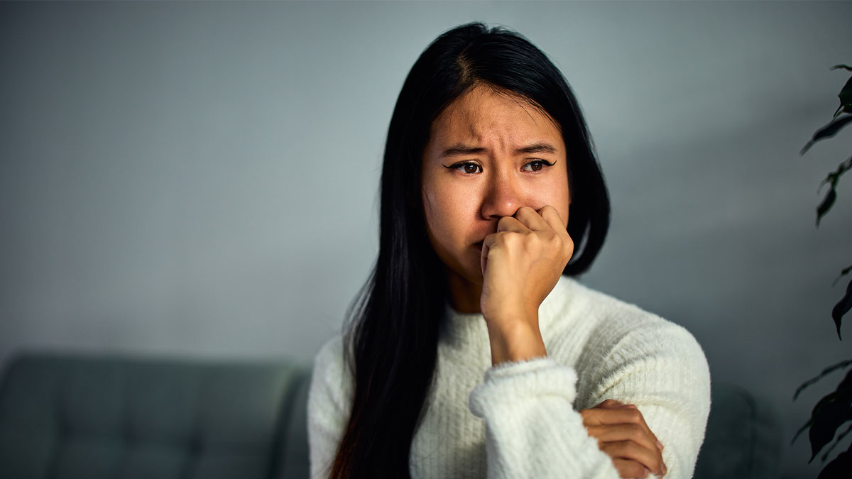 Young woman looking anxious and upset, capturing emotional impact of a man announces breakup to everyone except his girlfriend.