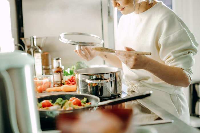 Woman cooking in a kitchen, preparing a meal while considering boyfriend mother family expectations. Woman cooking in a kitchen, preparing a meal while considering boyfriend mother family expectations.