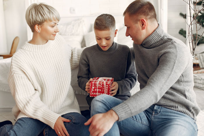 Young boy holding a gift with parents nearby, depicting themes of family dynamics and rich golden child allowance demands.