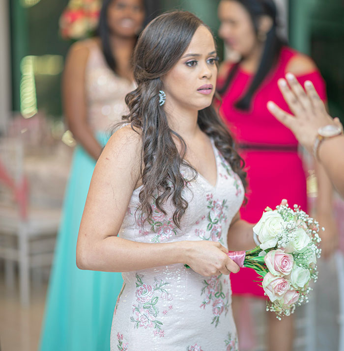 Bride looking horrified at wedding while holding bouquet, upset about cousin wearing long white dress with mom's approval. Bride looking horrified at wedding while holding bouquet, upset about cousin wearing long white dress with mom's approval.