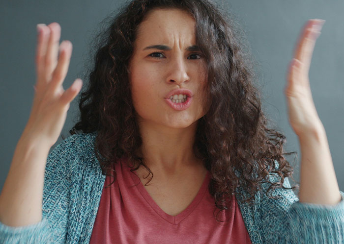 Frustrated woman gesturing with hands, expressing embarrassment while speaking to new colleague in a claimed language she knows well. Frustrated woman gesturing with hands, expressing embarrassment while speaking to new colleague in a claimed language she knows well.